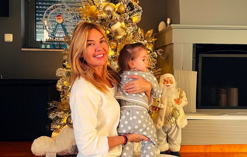 Η Χριστίνα Παππά αγκαλιά με την εγγονή της μπροστά στο Χριστουγεννιάτικο δέντρο